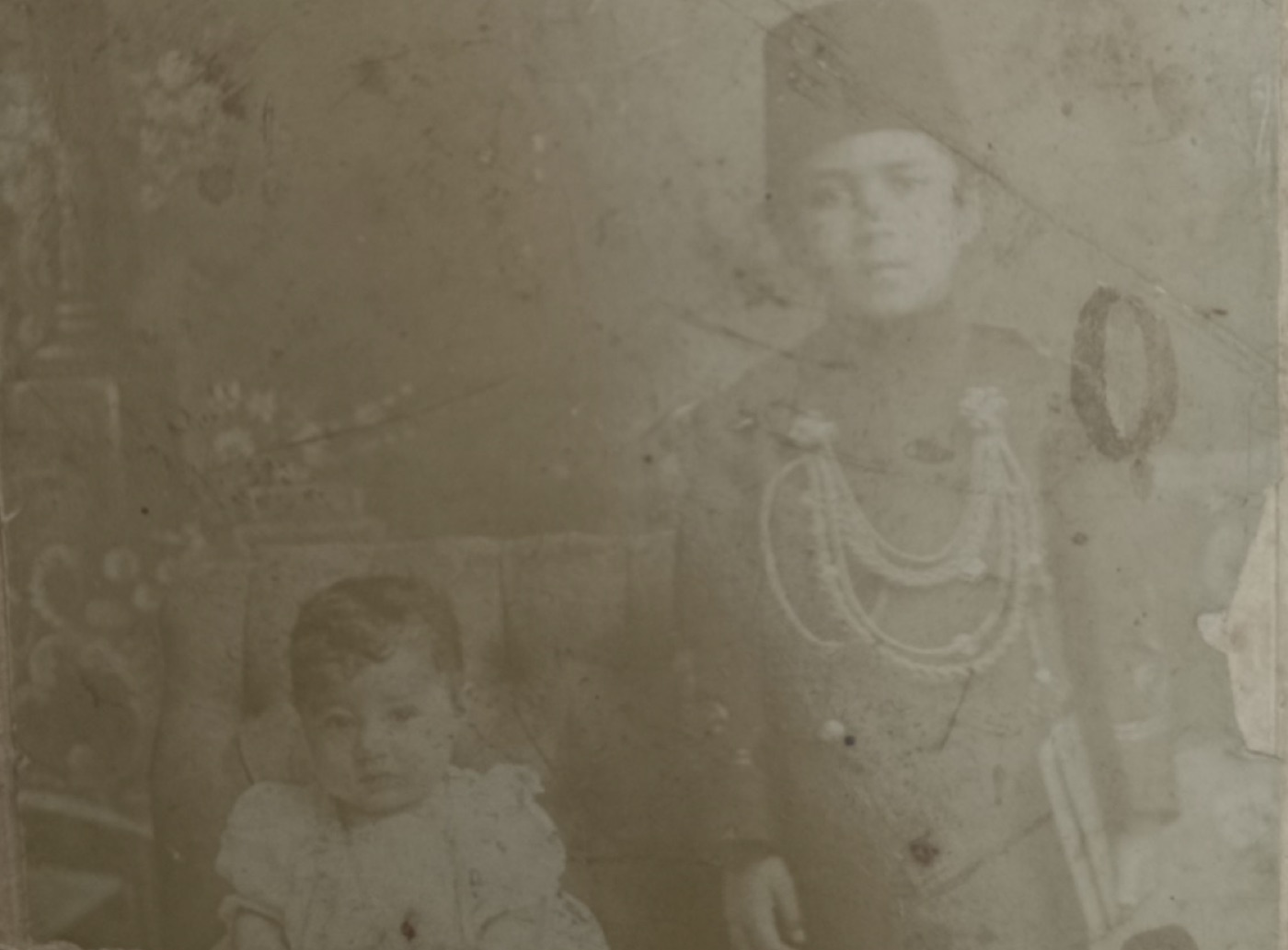 Fesli genç bir adam ve yanında bir çocuk, eski stüdyo fotoğrafı — Mustafa İloğlu arşivi